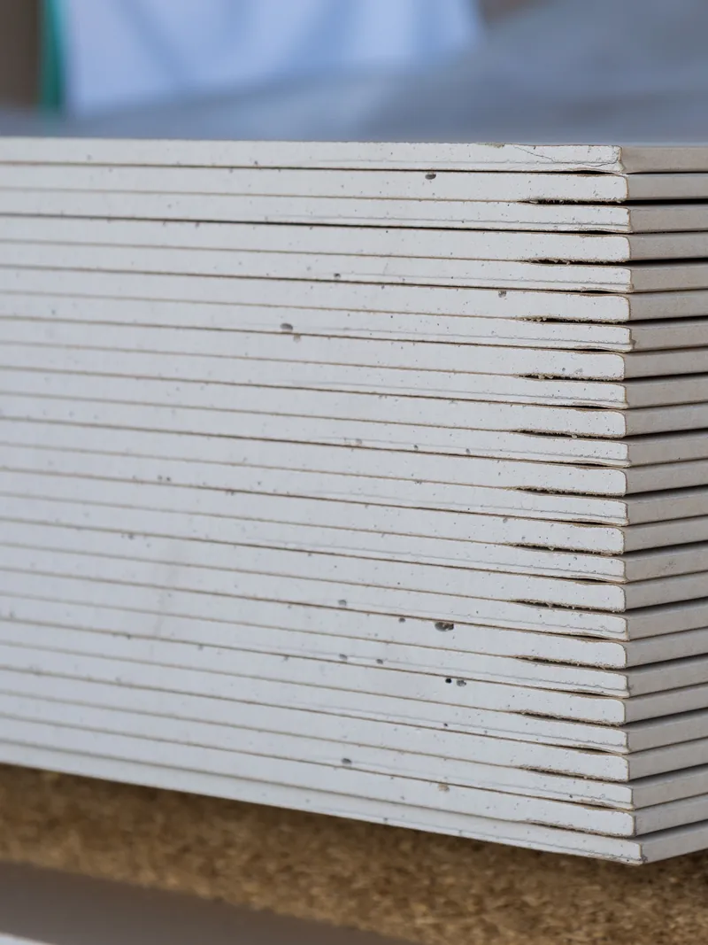 The cut edges of a stack of gypsum panels seen close up