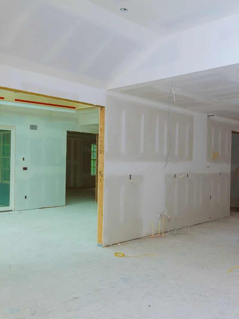 A long boarded corridor with openings cut for doors and services