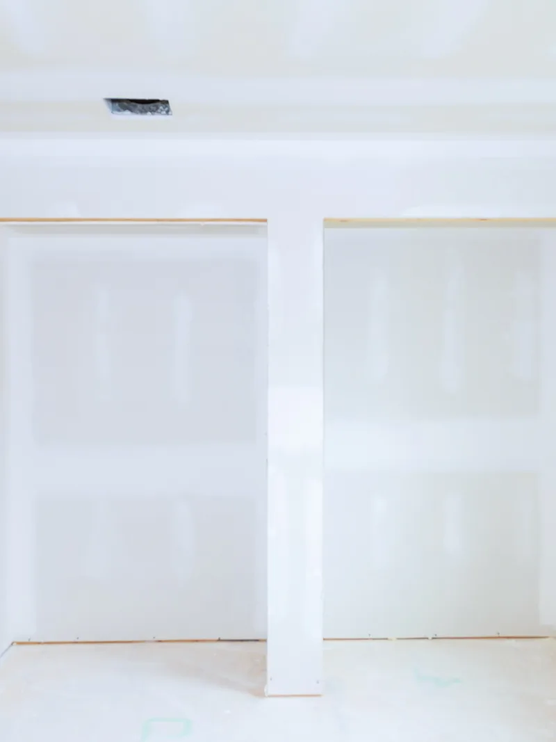 A boarded room with two doorways and the seams taped but not sanded