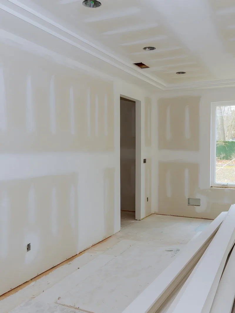 A large boarded room with unused panels stacked flat on the floor
