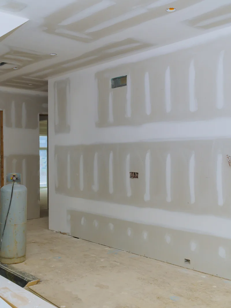 A boarded corridor with panels leaning against the wall ready to hang
