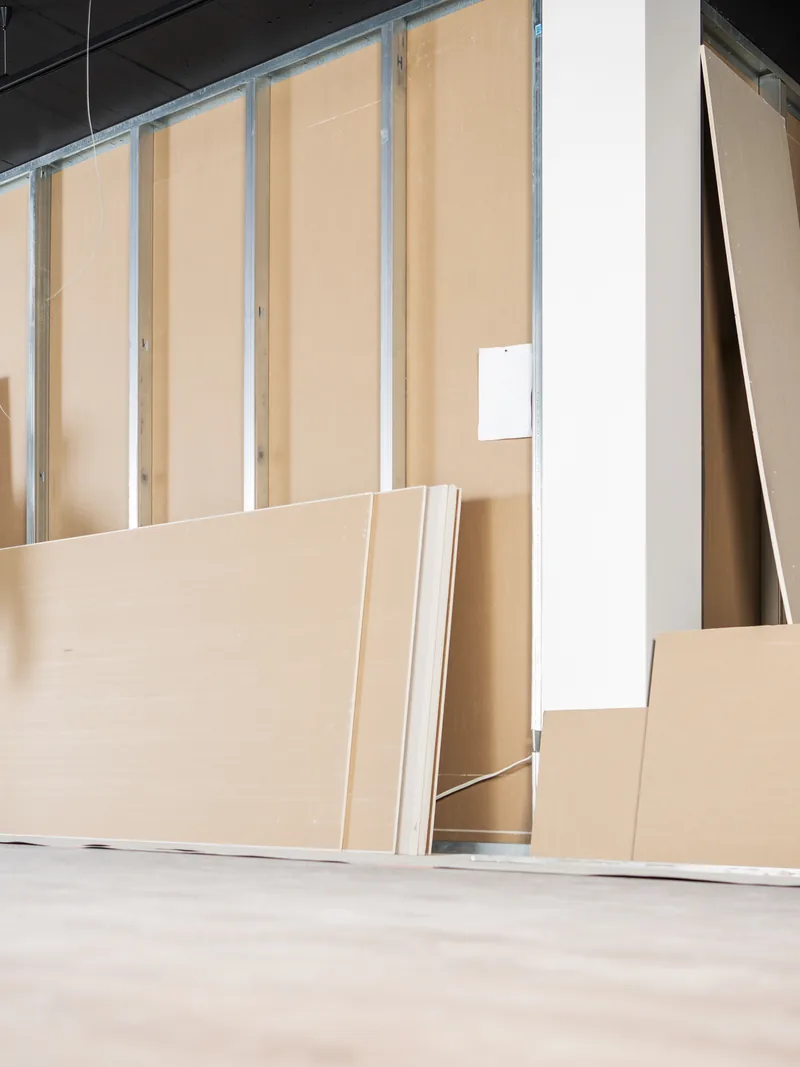 A long steel-framed commercial space with panels stacked ready to hang