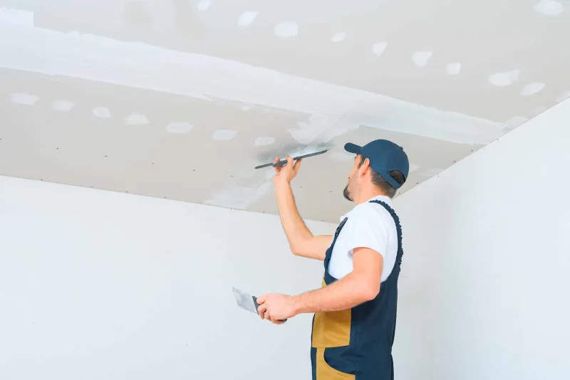 Finisher coating taped seams on a new drywall ceiling