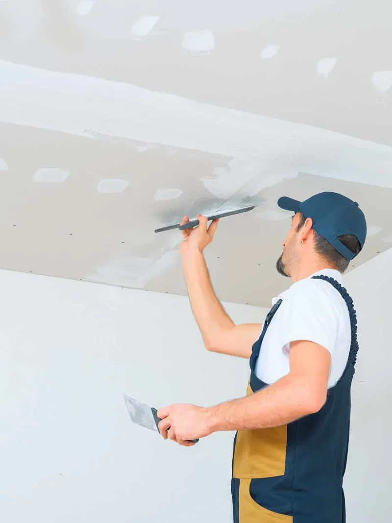 Finisher coating taped seams on a new drywall ceiling