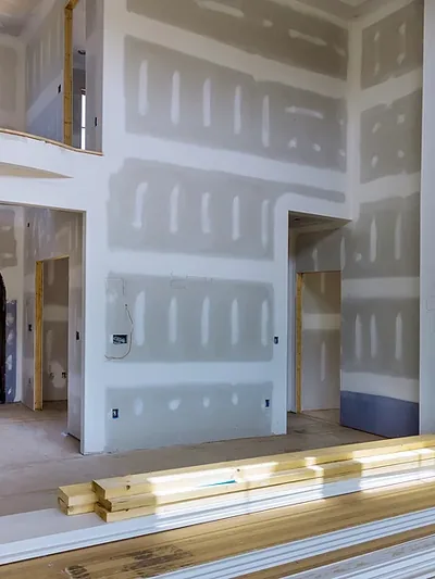 A tall boarded room with coffered ceiling detail and arched openings