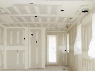 A boarded room with a stepped ceiling detail and recessed light cut-outs