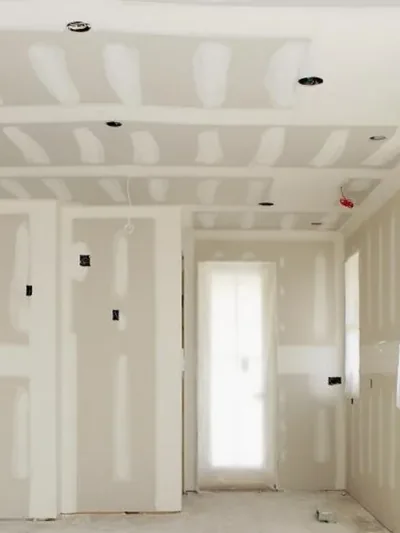 A boarded room with a stepped ceiling detail and recessed light cut-outs