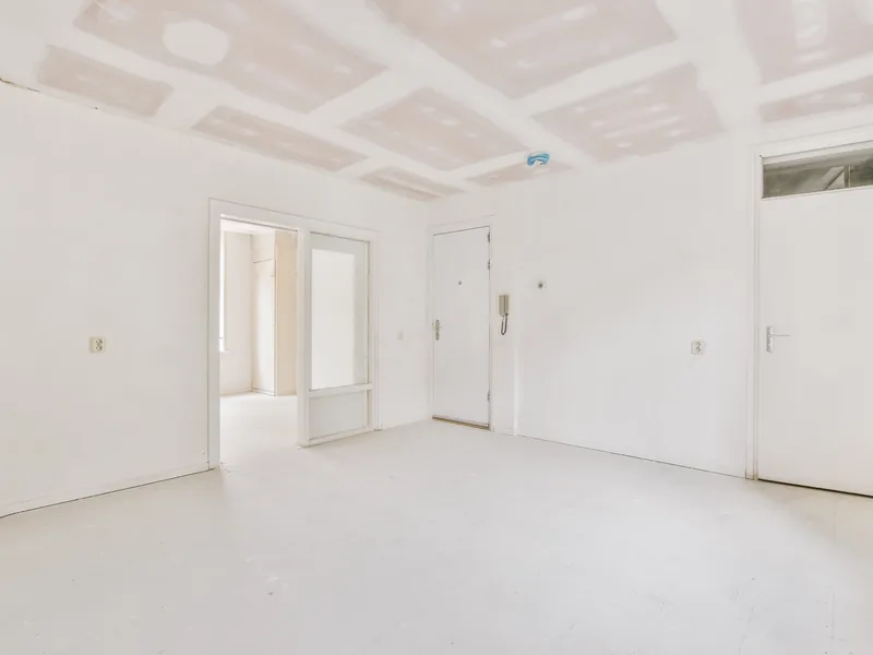 An empty room with plain white walls and ceiling and no trim yet
