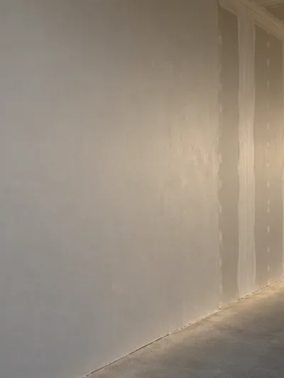 A wall under raking light with a skimmed area beside a joint-only finish