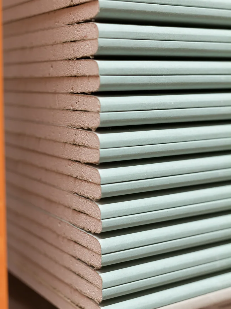 A stack of green-faced moisture-resistant panels seen end-on