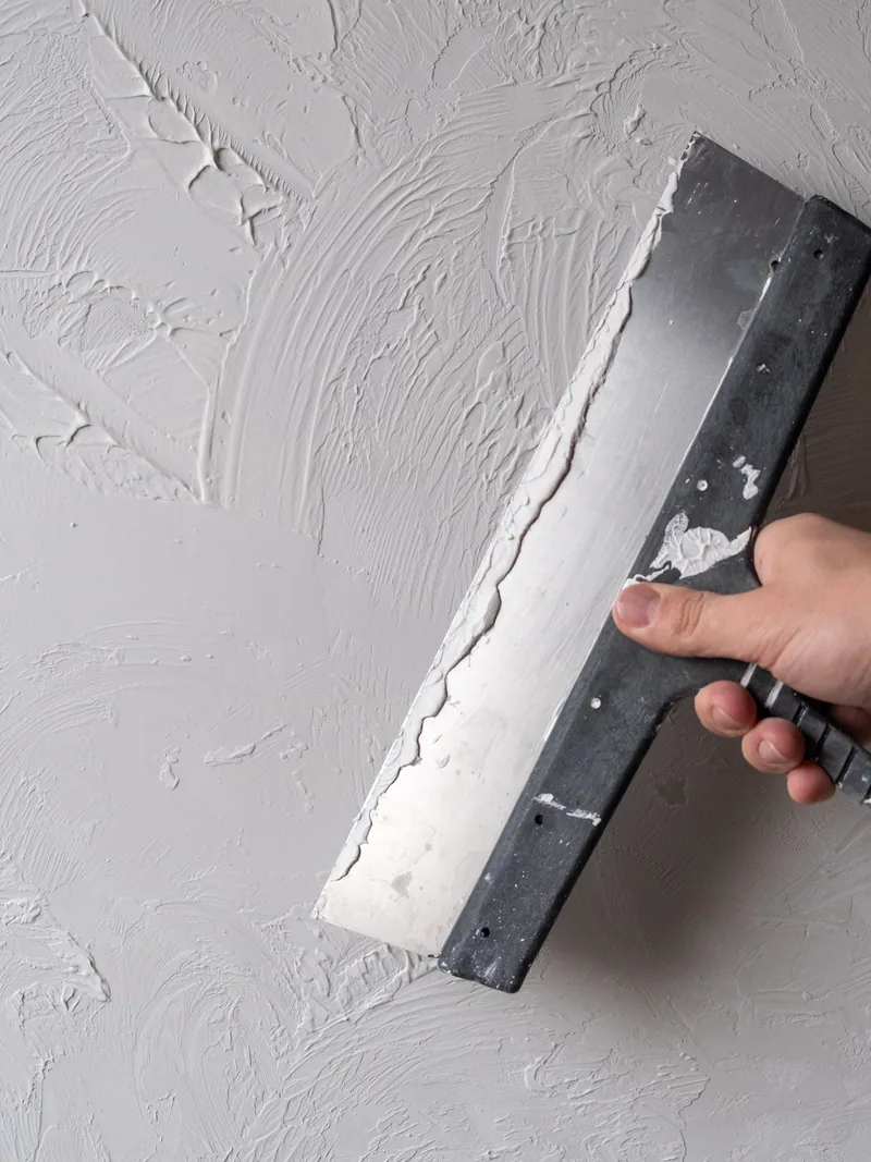 A knife drawn across a wall that already carries a hand-applied texture