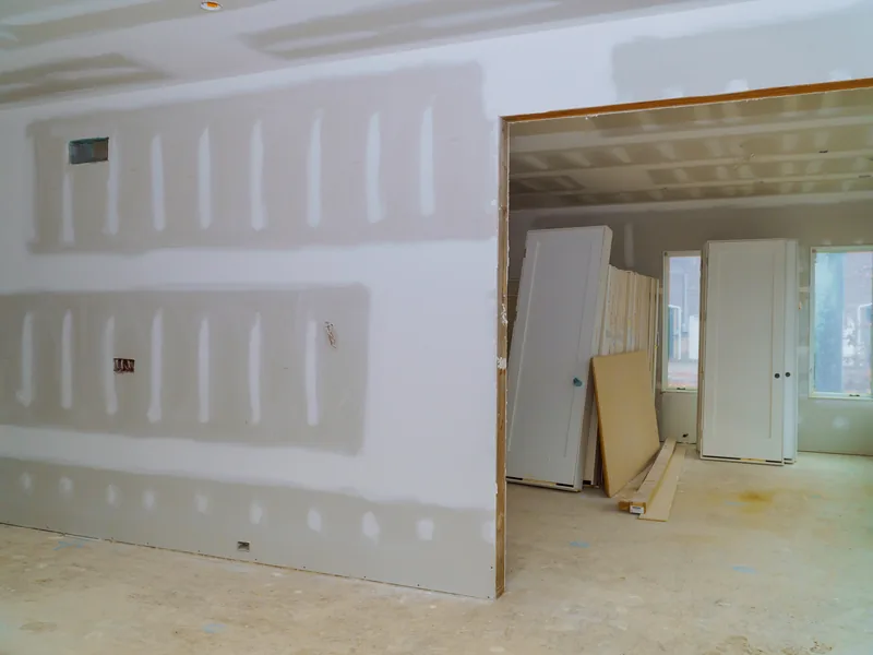 A boarded room with an offcut panel leaning by the window
