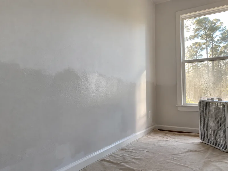 A wall part-primed, with the wet edge still darker than the dried area