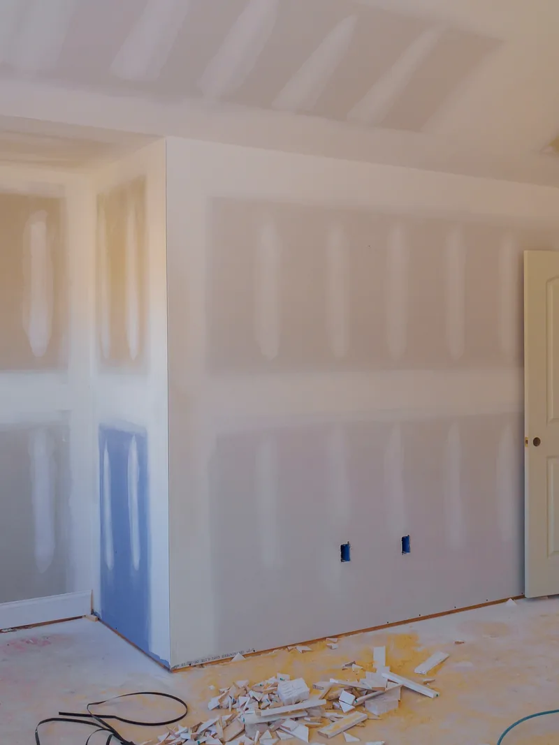 A part-renovated room with taped walls and a cabinet run going in
