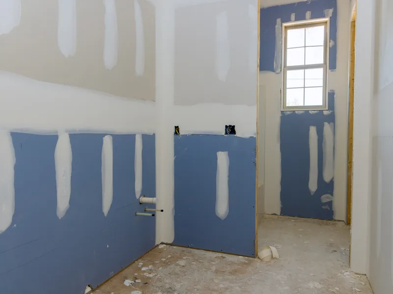 A bathroom stripped back with blue-faced board on the lower walls