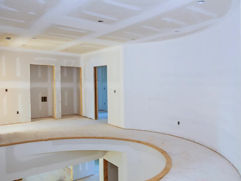 A curved boarded wall sweeping round beneath a coffered ceiling
