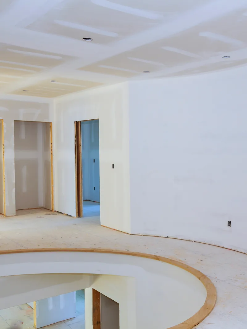 A curved boarded wall sweeping round beneath a coffered ceiling