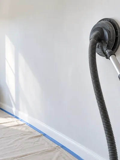 A vacuum-fed pole sander at work with an air scrubber running behind it